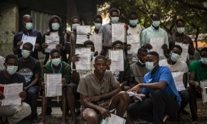 Un grupo de migrantes malienses muestra su expediente de devolución en una plaza de Las Palmas de Gran Canaria, cerca del centro de acogida en el que esperan más de un mes después de llegar en patera a la isla.- JAIRO VARGAS