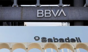 Los logos de BBVA y Banco Sabadell, en sus respectivas sedes en la zona norte de Madrid y en Alicante.