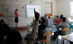 Un alumno levanta la mano en un aula.
