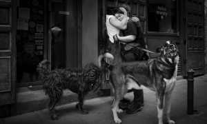 Un hombre abraza a una mujer mientras pasean a los perros. - Carmenchu Alemán
