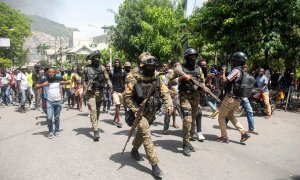 Policías haitianos escoltan a un grupo de personas mientras conducen detenidos a dos extranjeros en Puerto Principe , Haití