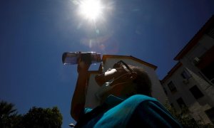 Un hombre bebe agua para aliviar las altas temperaturas registradas en Córdoba.