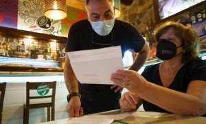 Personal de una cafetería de Santa Cruz de Tenerife, comprueba el certificado Covid de una clienta.