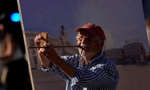 Antonio López revisa las perspectivas durante una de sus sesiones para pintar la famosa Puerta del Sol de Madrid. — Juan Medina / REUTERS