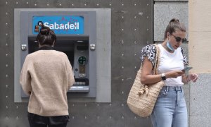 Dos mujeres en un cajero de una sucursal de banco Sabadell. Foto de archivo.