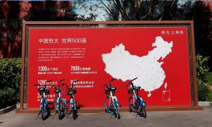 Una valla publicitaria cerca de una oficina de ventas de una promoción de viviendas de Evergrande, con un mapa que muestra los proyectos desarrollados por la inmobiliaria en el país, en Pekín. REUTERS / Carlos García Rawlins