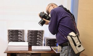 Un fotoperiodista realiza una fotografía a varios tomos de las enmiendas presentadas a los Presupuestos del Estado para 2022, en la Comisión de Presupuestos. E.P./Eduardo Parra