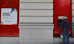 Un hombre opera en un cajero automático de una oficina del Banco Santander en Madrid. GABRIEL BOUYS / AFP