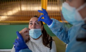 Un trabajador sanitario realiza un test de antígenos a una mujer durante el cribado poblacional celebrado en Ribadavia, en Ourense, este 27 de enero de 2022.