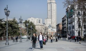 Una mujer camina sin mascarilla y un hombre con mascarilla, a 10 de febrero de 2022, en Madrid