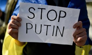 Un manifestante sostiene un cartel que dice 'Stop Putin' durante una protesta contra la operación militar de Rusia en Ucrania, frente al consulado ruso en Barcelona el 24 de febrero de 2022.