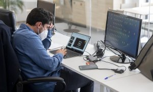 Un trabajador con mascarilla quirúrgica, el día en que ha entrado en vigor el decreto que pone fin al uso de la mascarilla en la mayoría de interiores, en la consultora de Marketing Alkemy, a 20 de abril de 2022, en Madrid (España).