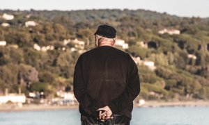 Un hombre mayor observa el mar.