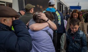Refugiados ucranianos se abrazan este martes 3 de mayo de 2022 tras llegar al estacionamiento de un centro comercial en Zaporiyia (Ucrania).