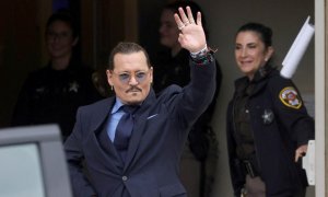 El actor Johnny Depp hace un gesto al salir del juzgado de circuito del condado de Fairfax