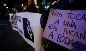 Una mujer sostiene un cartel en el que se lee "nos tocan a una, nos tocan a todas" en una manifestación feminista en Madrid.