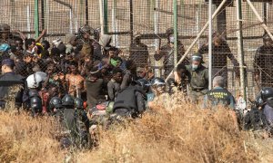 29/06/2022 Un miembro de las fuerzas de seguridad marroquí se lleva detenido a un migrante desde el lado español de la frontera con Melilla