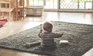 Fotografía de un bebé de espaldas jugando