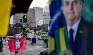 Partidarios del actual presidente Bolsonaro y del exjefe de Estado Lula da Silva promocionan a sus candidatos con banderas y carteles frente a los automovilistas en un semáforo en rojo