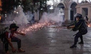 Un manifestante y un agente de Policía durante los enfrentamientos en el centro de Lima, Perú, a 11 de diciembre de 2022.