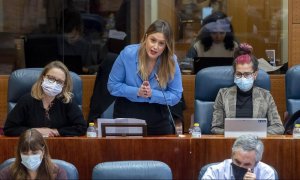 Carolina Alonso, Alejandra Jacinto (de pie) y Vanesa Lillo, portavozas de Unidas Podemos en la Asamblea de Madrid