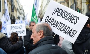 Un hombre con una pancarta que reza '¡Pensiones garantizadas!' en una marcha por el blindaje de las pensiones en Madrid. E.P./Gustavo Valiente