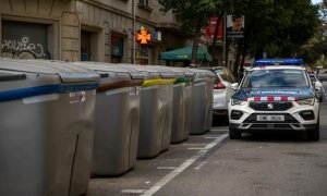 Un coche de la Policía aguarda junto a un contenedor del centro de Barcelona, a 29 de noviembre de 2022.