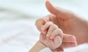 Una mujer da la mano a un bebé (Archivo)
