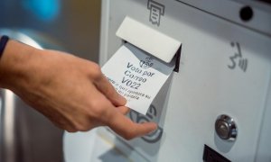 Una persona recoge el ticket para solicitar el voto por correo, a 14 de junio de 2023 en Madrid