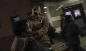 Un hombre traslada a una mujer herida tras un ataque de Israel a un hospital de la Franja de Gaza, a 17 de diciembre de 2023.