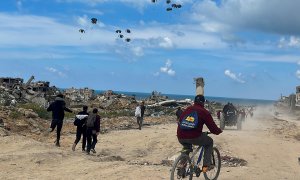 26/3/24- Los palestinos se apresuran hacia la playa para recoger la ayuda lanzada desde un avión, en medio del actual conflicto entre Israel y Hamás, en el norte de la Franja de Gaza, a 25 de marzo de 2024.