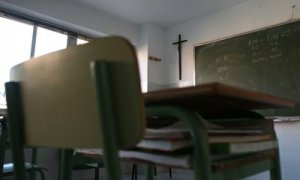 Aula de un centro educativo concertado en Madrid presidida por un crucifijo.