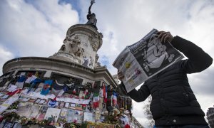 Un hombre ojea el número especial publicado por el semanario satírico 'Charlie Hebdo' con motivo del primer aniversario del atentado yihadista contra su redacción, en la Plaza de la República de París. EFE/Ian Langsdon