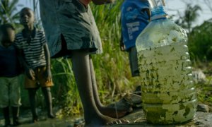 En la imagen, niños de Owino Uhuru, un asentamiento chabolista de Mobasa (Kenia), recogen agua aún contaminada por los vertidos de plomo de una empresa de reciclaje de baterías de coche que fue cerrada después de que murieran y enfermaran numerosos habita