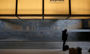 Un hombre debajo del logo de Telefonica, en la sede de la compañía en el distrito de Las Tablas, en el norte de Madrid. REUTERS/Juan Medina