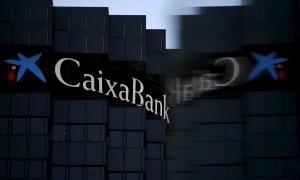 El logo de CaixaBank se refleja en un cristal, en la sede de la entidad en Barcelona. REUTERS/Albert Gea