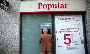 Un hombre utiliza un cajero de una oficina del Banco Popular en Madrid. REUTERS/Andrea Comas