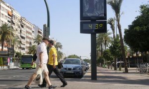 Dos personas pasan junto a un termómetro en Córdoba. - EFE