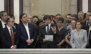 El presidente de la Generalitat, Carles Puigdemont (c) junto al vicepresidente del Govern y conseller de Economía, Oriol Junqueras y la presidenta del Parlament, Carme Forcadell, realiza una declaración en las escalinatas del Parlamen del Parlament tras a