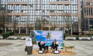 Dos actores "toman el sol en un paraíso fiscal" durante una acción de protesta de Oxfam delante del Consejo Europeo, en Bruselas (Bélgica). EFE/ Stephanie Lecocq