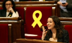 La líder de C's al Parlament, Inés Arrimadas, amb la número 2 d'ERC, Marta Rovira, en segon pla, al costat d'un llaç vermell a l'escó bit que correspon a Oriol Junqueras, en el ple d'aquest dijous. EFE / Toni Albir