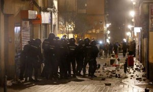 Policías antidisturbios en la calle Mesón de Paredes con la calle del Oso, en el barrio de Lavapiés de Madrid, repelen las protestas tras la muerte de un mantero de un paro cardíaco durante un control policial. | JAVIER LIZÓN (EFE)