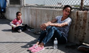 Una mujer hondureña y su hija que huyen de la violencia y la pobreza esperan en la frontera con EEUU tras haberles sido rechazada la entrada. SPENCER PLATT (AFP)