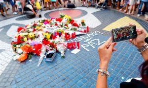 Una turista fotografía los ramos de flores y objetos de todo tipo depositados en el mural de Miro de La Rambla de Barcelona en recuerdo de los atentados en La Rambla y Cambrils. - EFE/Alejandro García