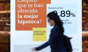 Una mujer pasa junto a una publicidad de hipotecas en una sucursal de Bankinter. REUTERS/Susana Vera