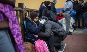Una pareja de solicitantes de asilo espera su turno para pedir cita y comenzar sus trámites en la comisaría de Aluche (Madrid).- JAIRO VARGAS