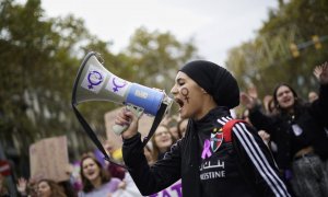 Una manifestant crida consignes feministes pel megàfon durant la marxa contra la violència masclista de Barcelona, aquest 25-N. Josel Kashila