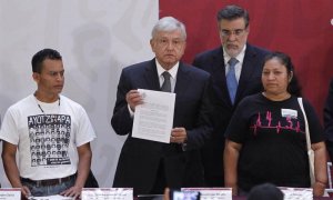 El presidente de México Andrés Manuel López Obrador  sostiene el decreto presidencial para la instalación de una Comisión de la Verdad junto a los padres de dos de las  víctimas de los 43 estudiantes de Ayotzinapa. (Sáshenka Gutiérrez | EFE)