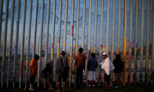 Un grupo de migrantes centroamericanos observa el muro fronterizo entre México y EEUU.- REUTERS/Mohammed Salem