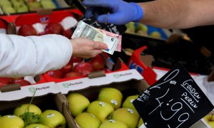 Un cliente paga su compra en un puesto de frutas y verduras de un mercado de Madrid. REUTERS/Sergio Perez